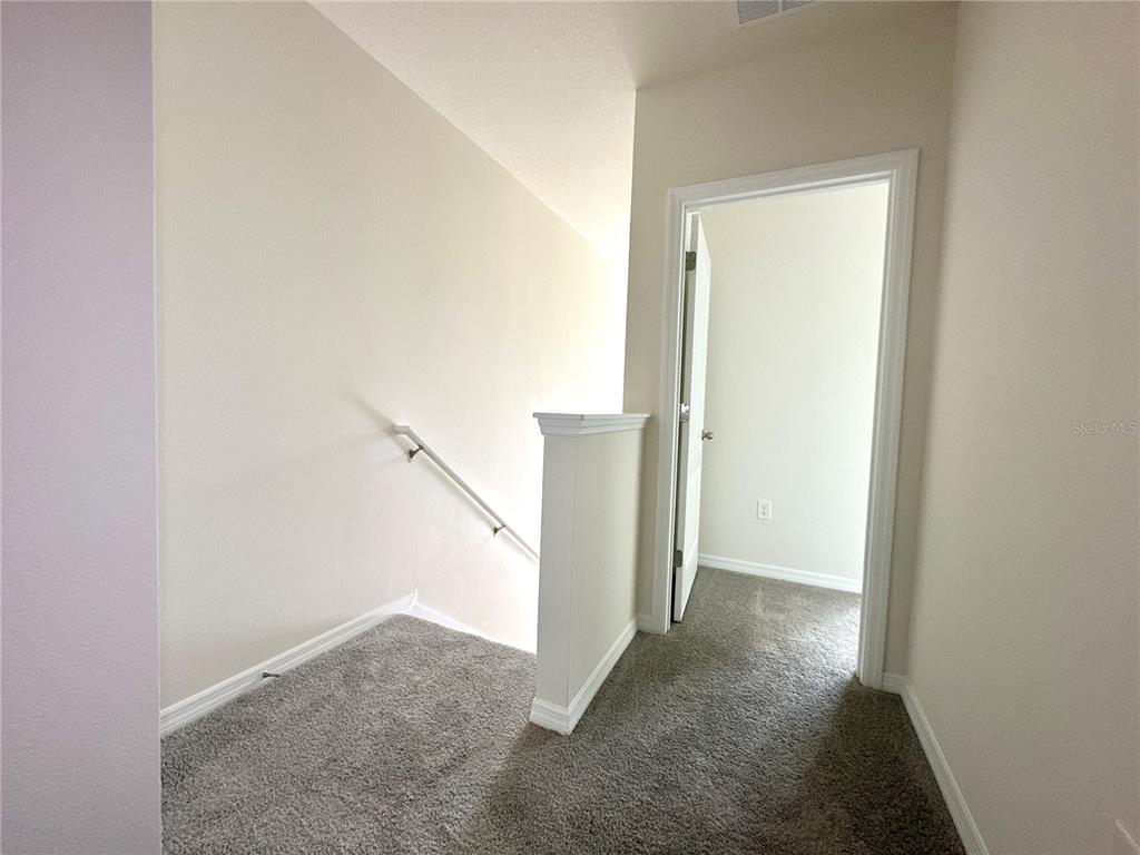 2742 Puffin Place Davenport, FL 33837 - Photo 18 of 31 a view of a hallway with staircase