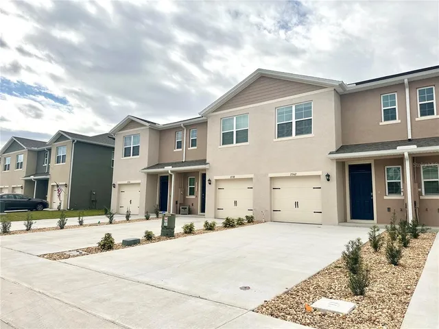 a view of a white house with a large tree