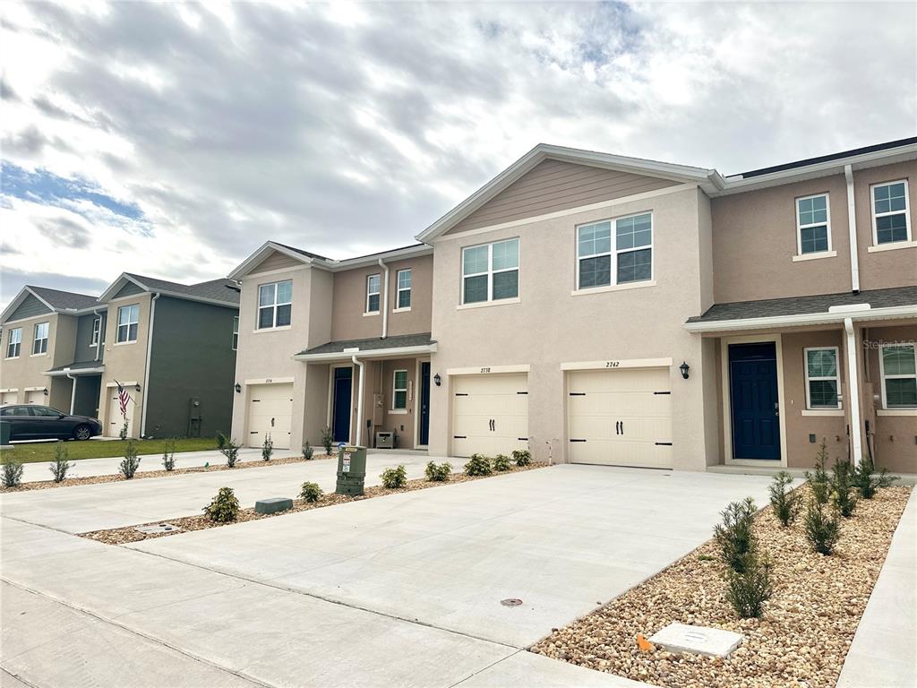 2742 Puffin Place Davenport, FL 33837 - Photo 2 of 31 a view of a white house with a large tree