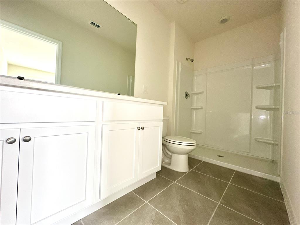 2742 Puffin Place Davenport, FL 33837 - Photo 23 of 31 a bathroom with a toilet and a shower