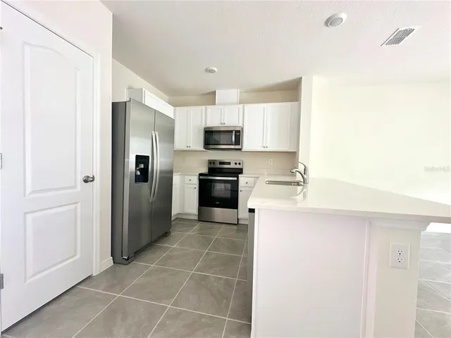 a kitchen with stainless steel appliances a refrigerator sink and stove
