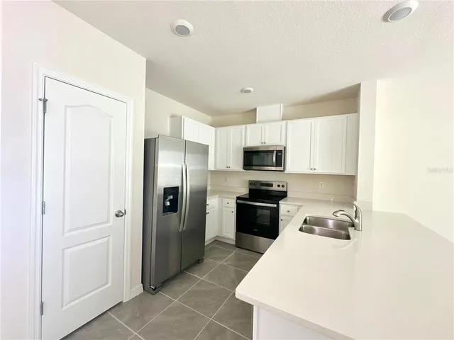 a kitchen with a sink stove and refrigerator