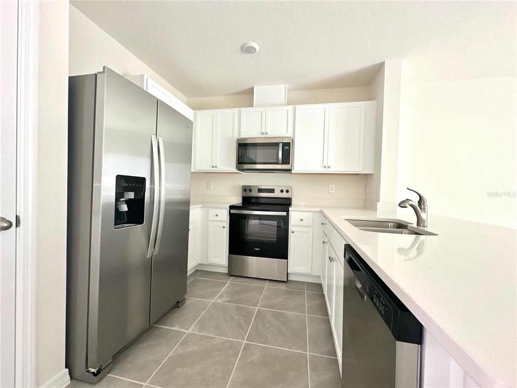 2742 Puffin Place Davenport, FL 33837 - Photo 8 of 31 a kitchen with a sink stove and refrigerator