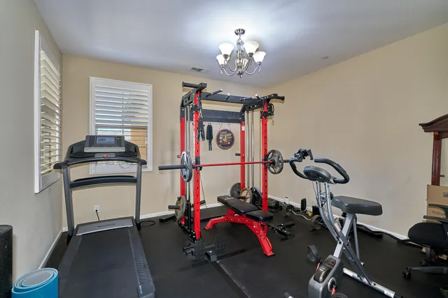 a view of a house with a yard and table and chairs under an umbrella