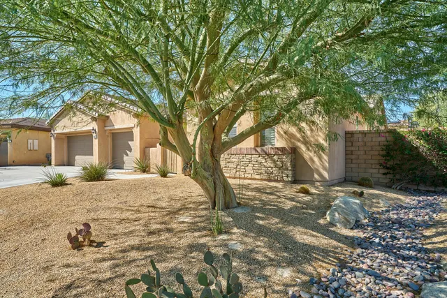 a view of a house with street that has a tree