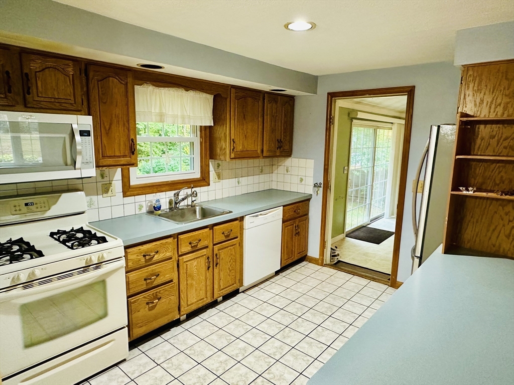 64 Maplewood Drive Townsend, MA 01469 - Photo 5 of 18 a kitchen with stainless steel appliances a stove a sink and a refrigerator with wooden cabinets