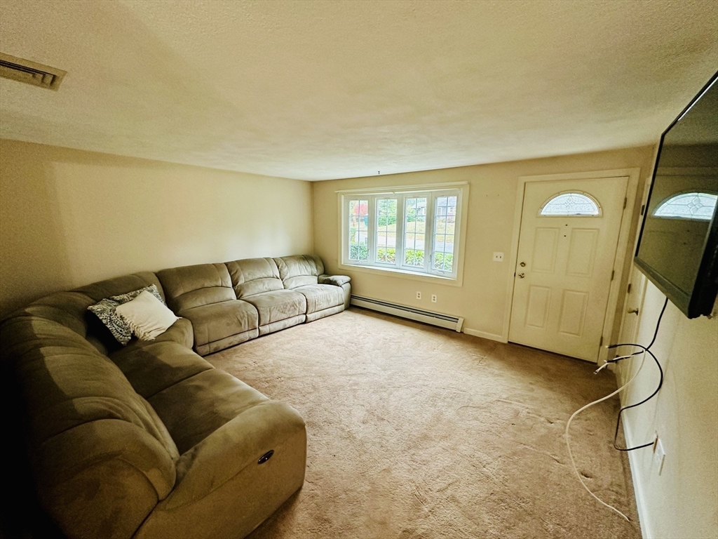 64 Maplewood Drive Townsend, MA 01469 - Photo 9 of 18 a living room with a couch and a flat screen tv