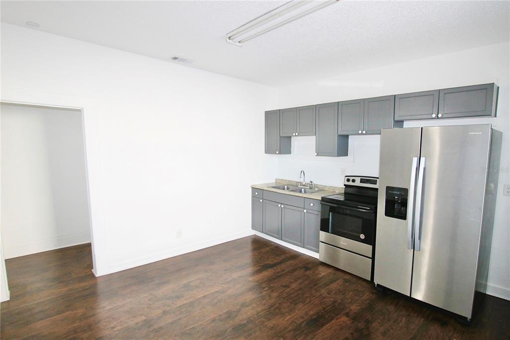 610 Dundee Road Dundee, FL 33838 - Photo 14 of 42 a kitchen with a refrigerator and a stove top oven