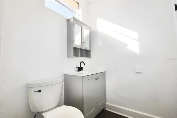 a bathroom with a toilet a sink and mirror