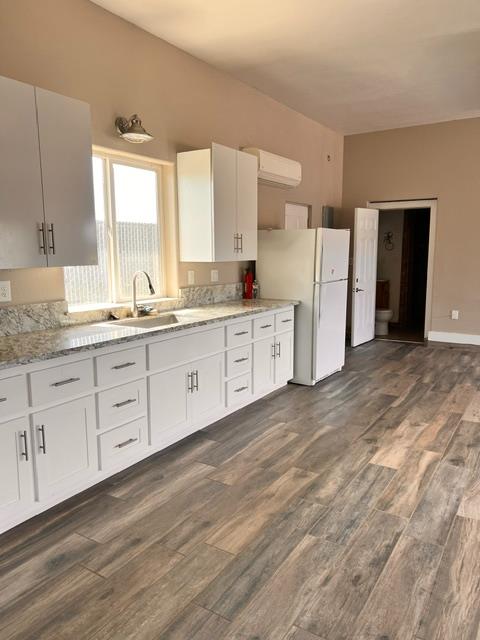 3019 Lathrop Road Manteca, CA 95336 - Photo 39 of 43 a kitchen with white cabinets and wooden floors