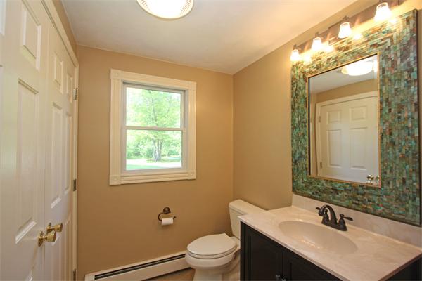 157 Kaleva Road Lancaster, MA 01523 - Photo 13 of 26 a bathroom with a granite countertop sink toilet a mirror and a window
