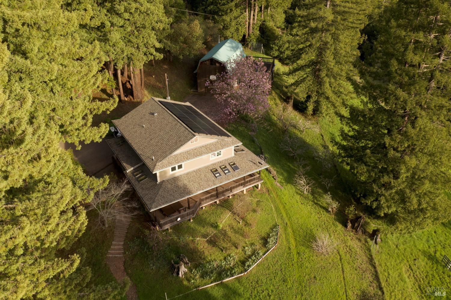 an aerial view of a house with a yard swimming pool and outdoor seating