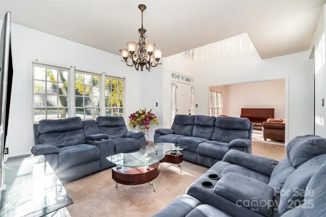 a living room with furniture and a chandelier