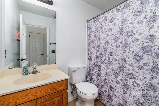 a bathroom with a granite countertop sink and a toilet