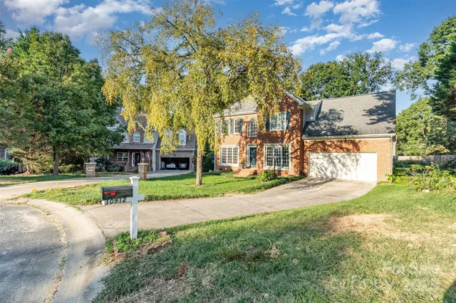 a view of a house with a yard and tree s