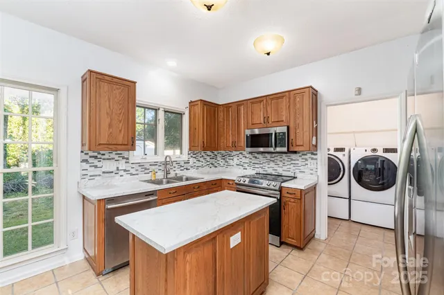 a kitchen with stainless steel appliances granite countertop a stove top oven a refrigerator a sink and dishwasher