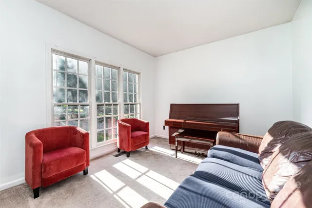 a living room with furniture a flat screen tv and a window