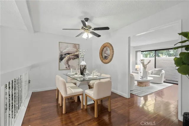 a view of a dining room with furniture a rug and wooden floor