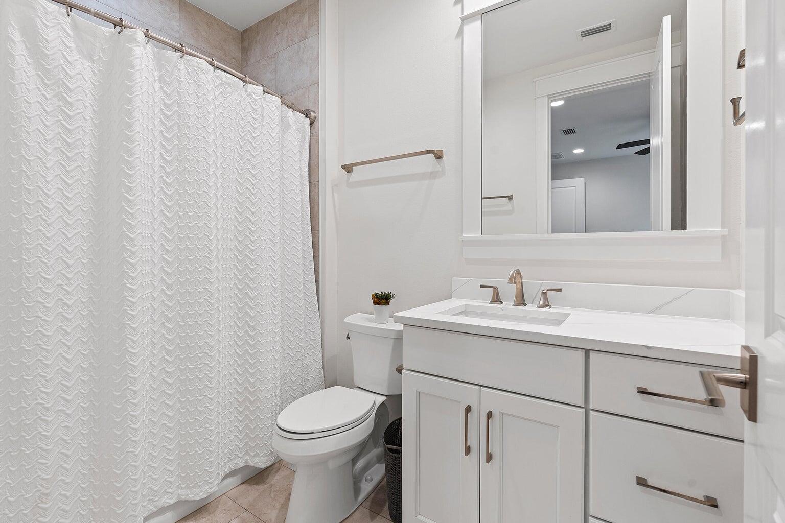 51 Sandchase Circle Watersound, FL 32461 - Photo 19 of 24 a bathroom with a toilet sink vanity and mirror