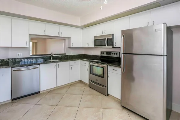 a kitchen with stainless steel appliances granite countertop a refrigerator sink and stove