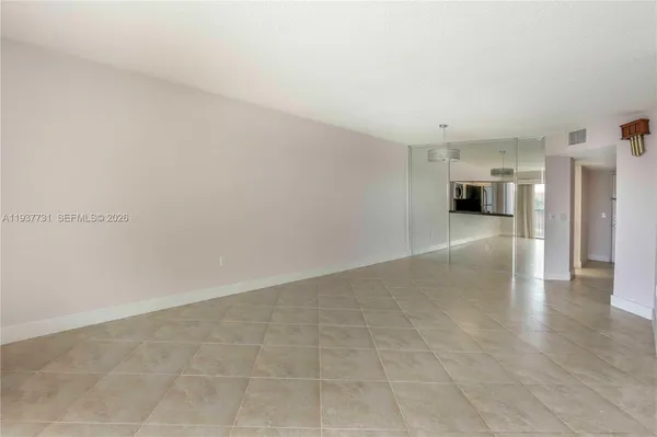 a view of a hallway with wooden floor and a kitchen space
