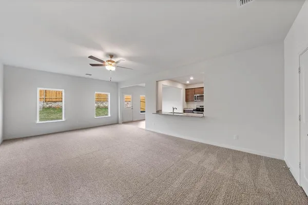 a view of a livingroom with a ceiling fan and window