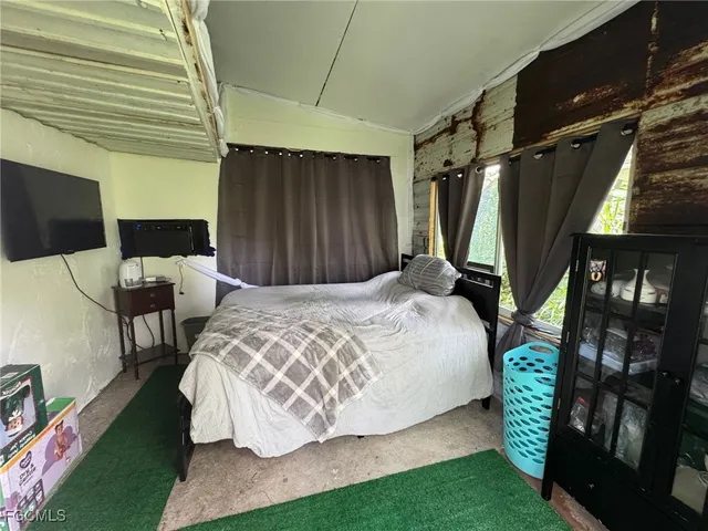 a bedroom with a bed window and a chair