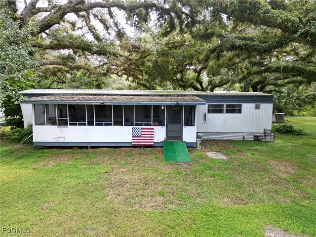 a view of a house with backyard sitting area and garden