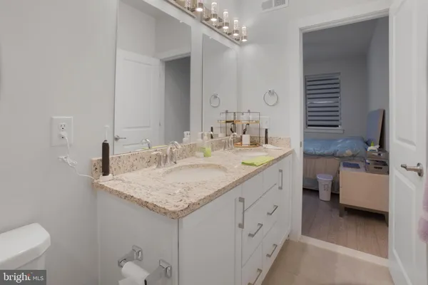 a bathroom with a granite countertop sink toilet and shower