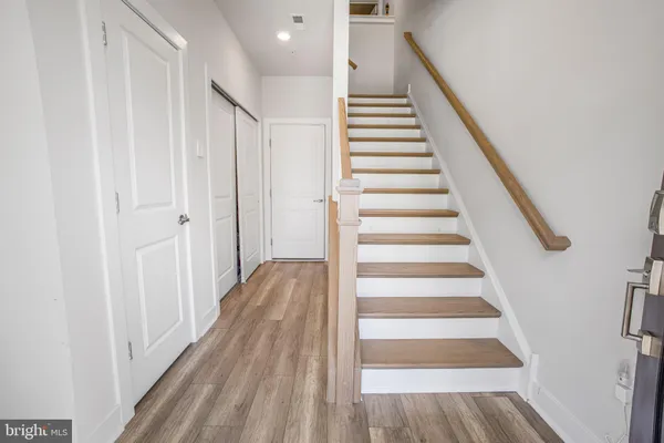 a view of a hallway with wooden floor and entryway
