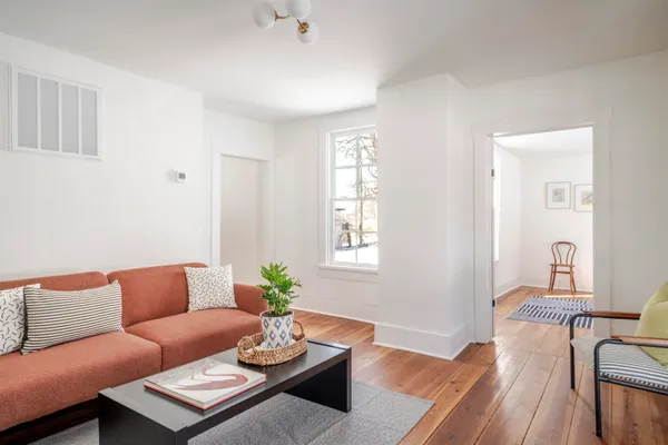 a living room with furniture and a wooden floor