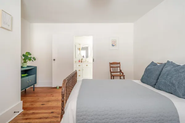 a bedroom with a bed and a potted plant