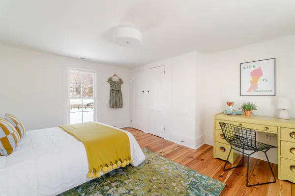 a bedroom with a bed and wooden floor