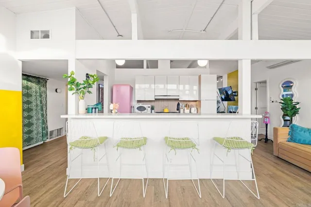 a kitchen with stainless steel appliances a stove a sink a refrigerator white cabinets and wooden floor