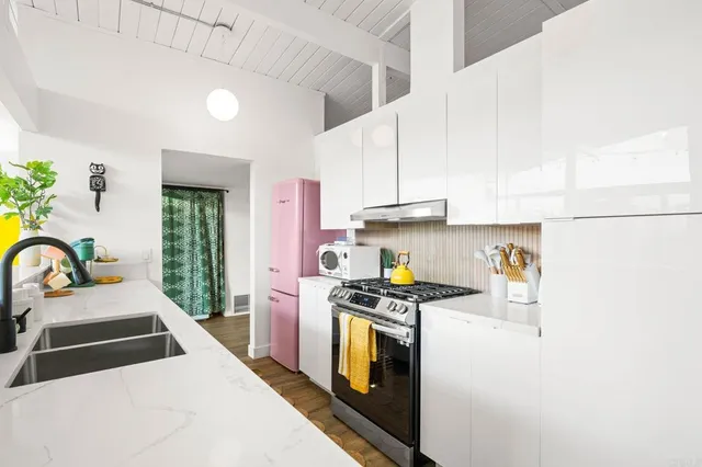 a kitchen with stainless steel appliances a sink stove and cabinets