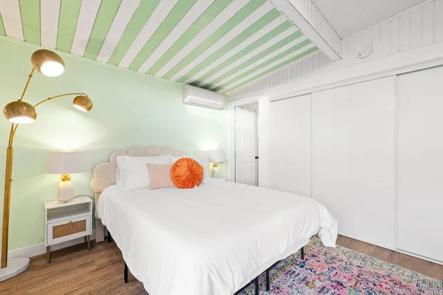 a bedroom with a bed a desk and chair with rug