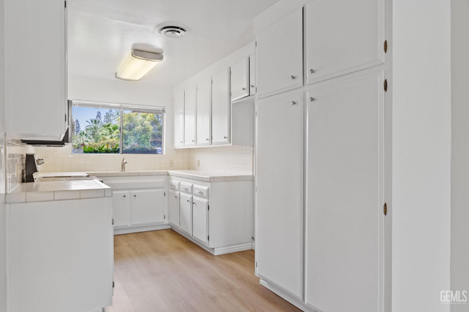 Undisclosed Address Bakersfield, CA 93306 - Photo 16 of 46 a kitchen with white cabinets and sink