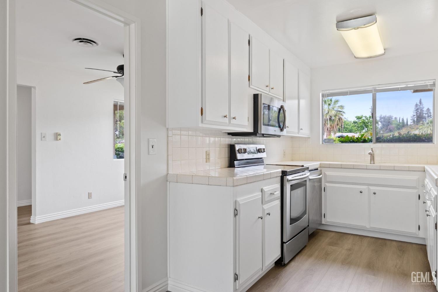 Undisclosed Address Bakersfield, CA 93306 - Photo 17 of 46 a kitchen with white cabinets and white appliances