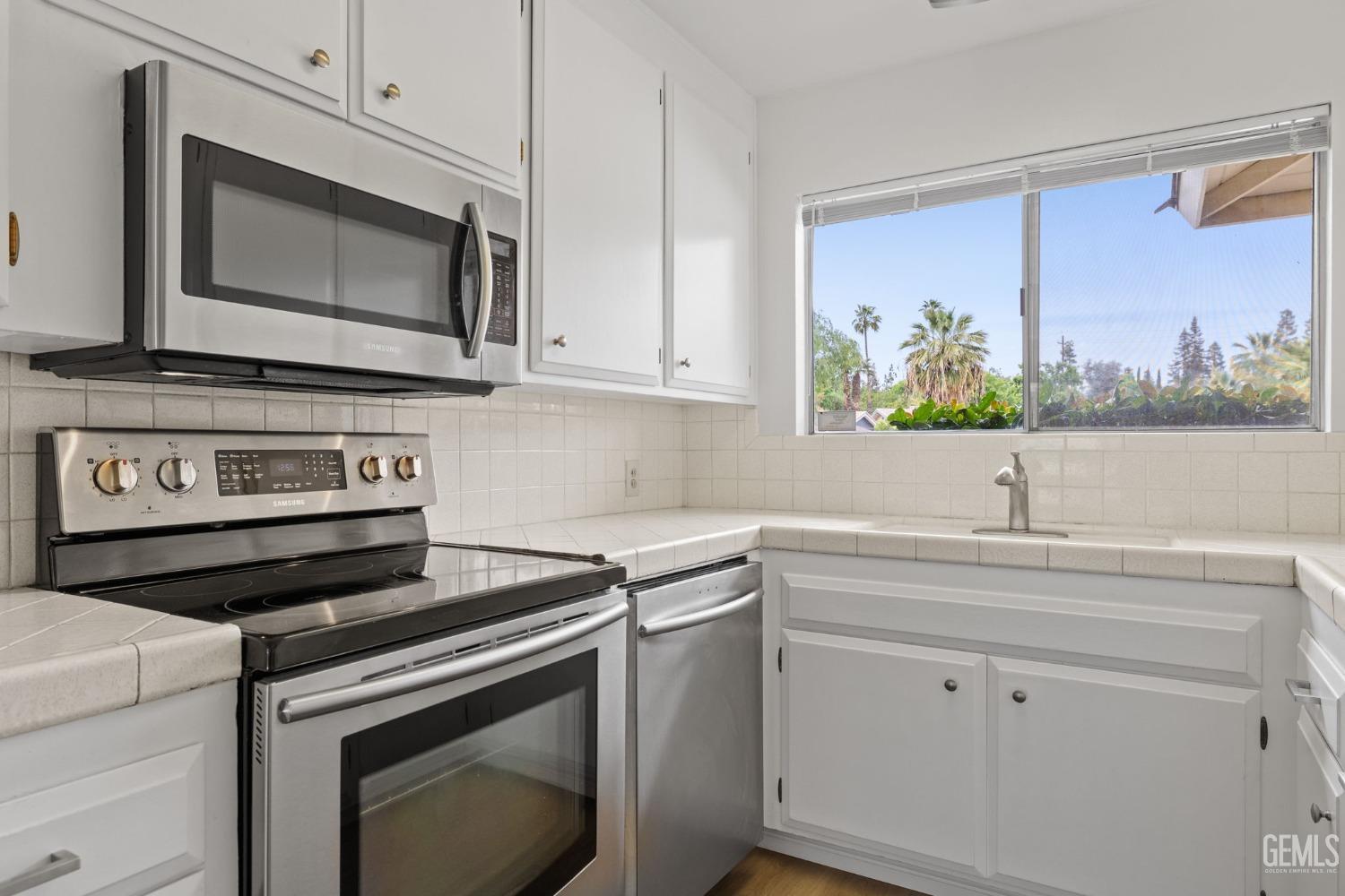Undisclosed Address Bakersfield, CA 93306 - Photo 19 of 46 a kitchen with stainless steel appliances white cabinets and a stove top oven