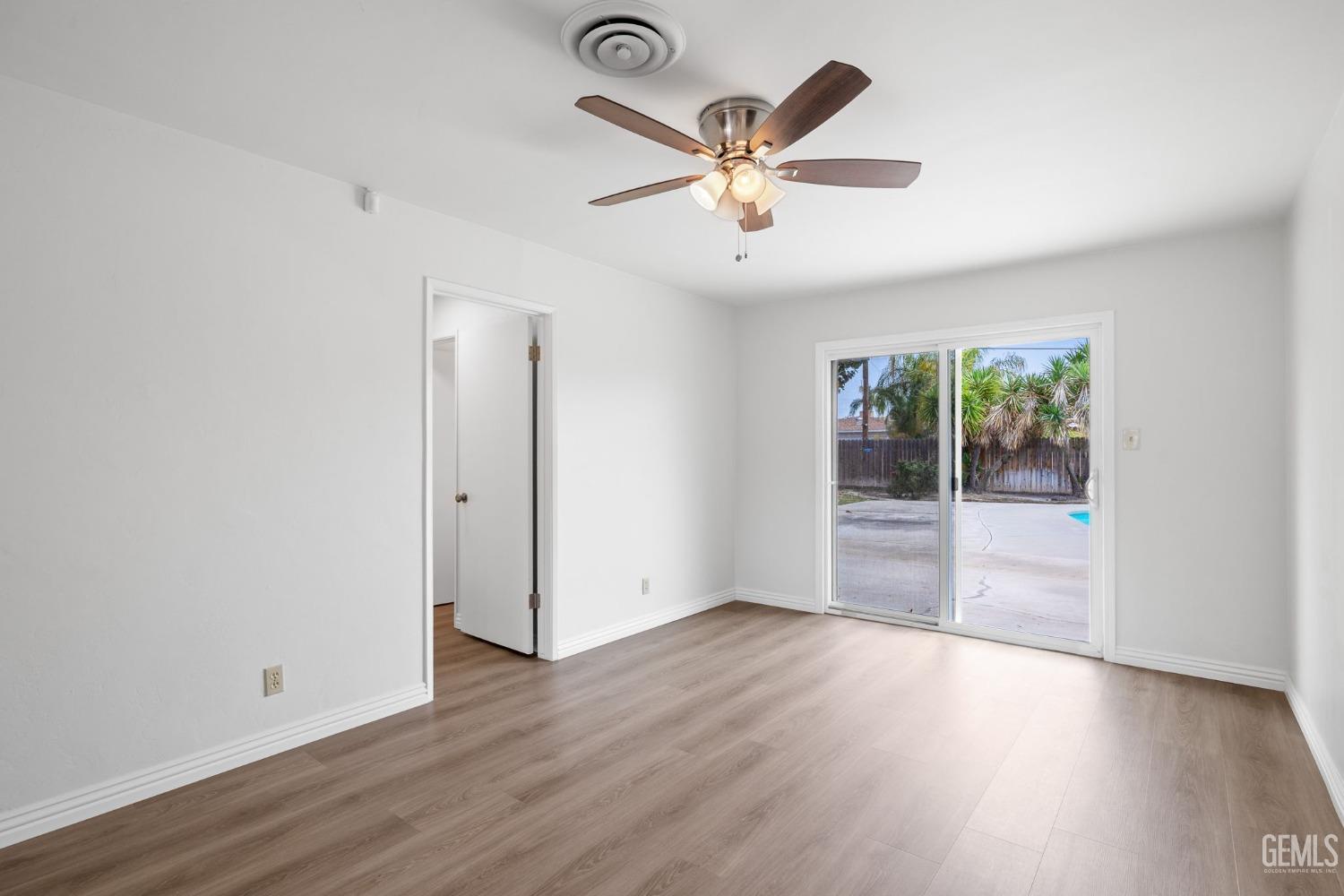 Undisclosed Address Bakersfield, CA 93306 - Photo 24 of 46 an empty room with wooden floor and windows