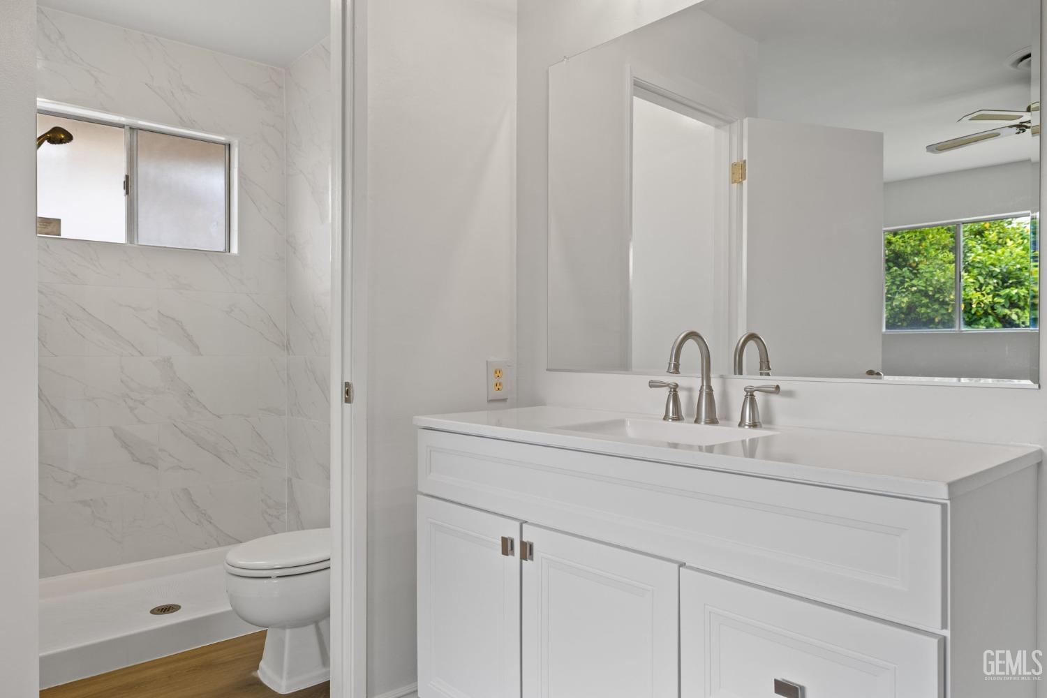 Undisclosed Address Bakersfield, CA 93306 - Photo 32 of 46 a bathroom with a granite countertop toilet a sink and a mirror