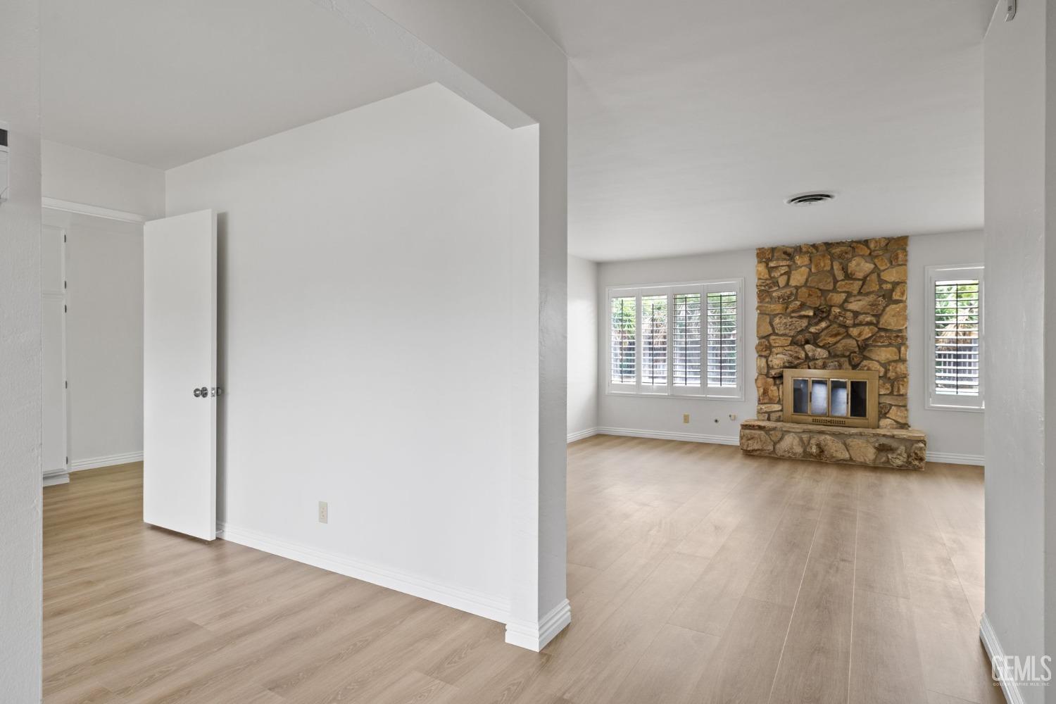 Undisclosed Address Bakersfield, CA 93306 - Photo 4 of 46 an empty room with wooden floor and fireplace