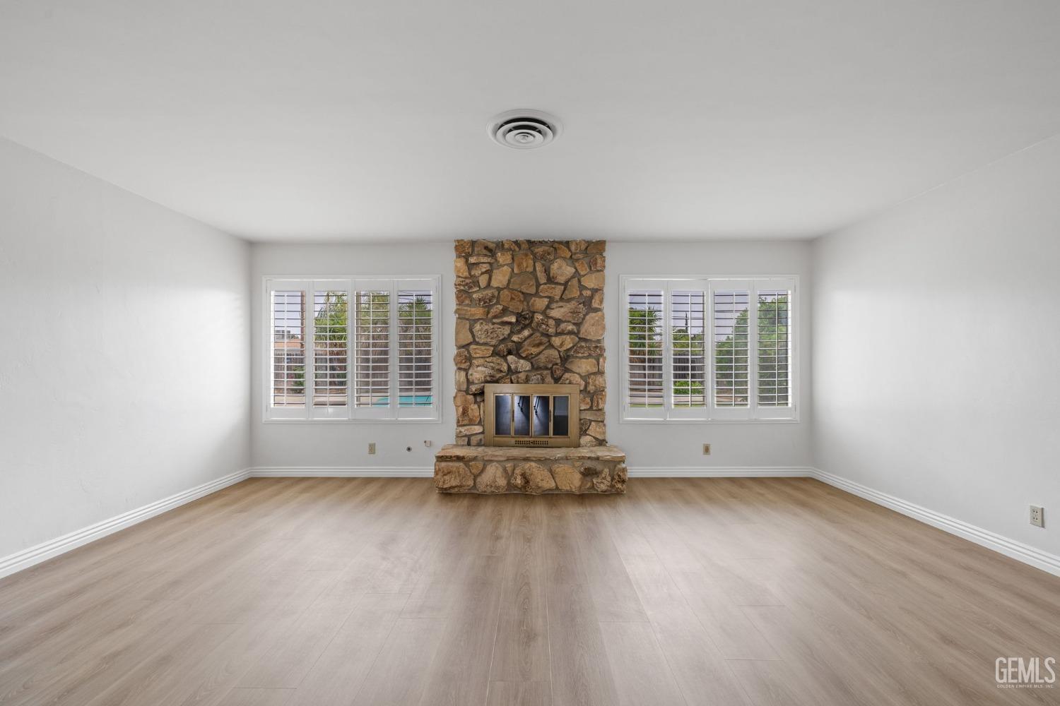 Undisclosed Address Bakersfield, CA 93306 - Photo 5 of 46 an empty room with wooden floor and windows