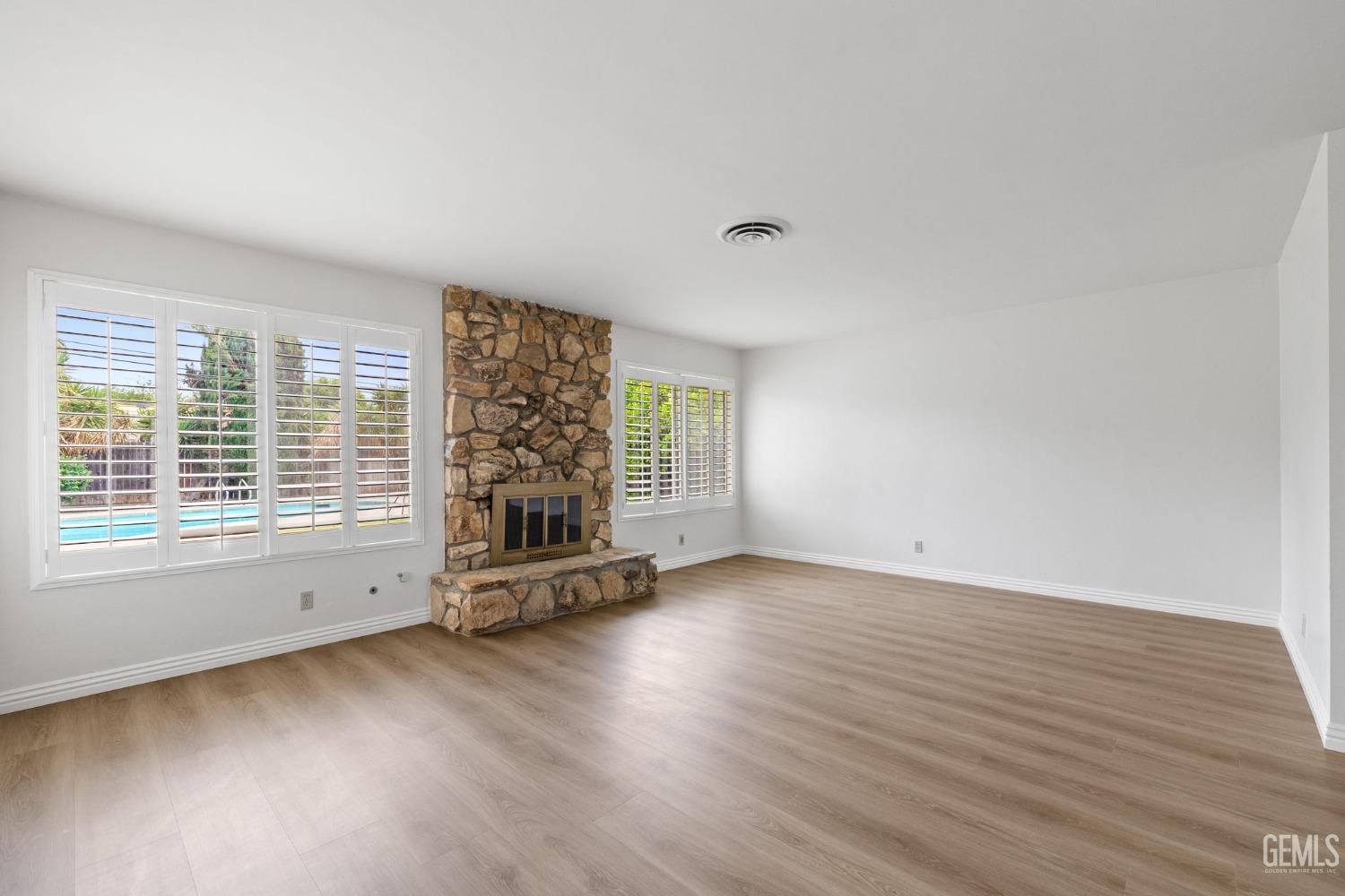 Undisclosed Address Bakersfield, CA 93306 - Photo 6 of 46 an empty room with wooden floor and windows