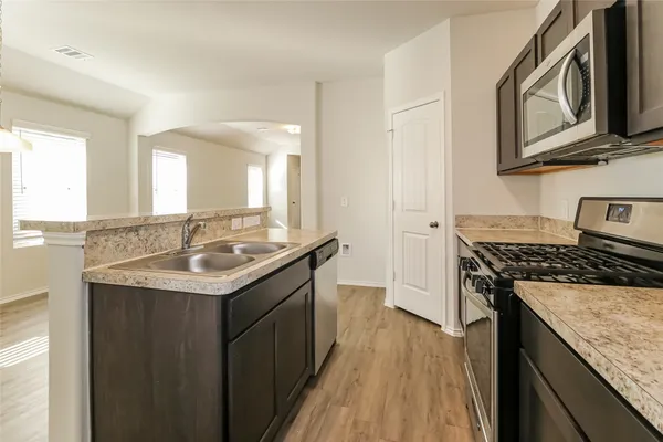 a kitchen with stainless steel appliances granite countertop a sink stove and cabinets