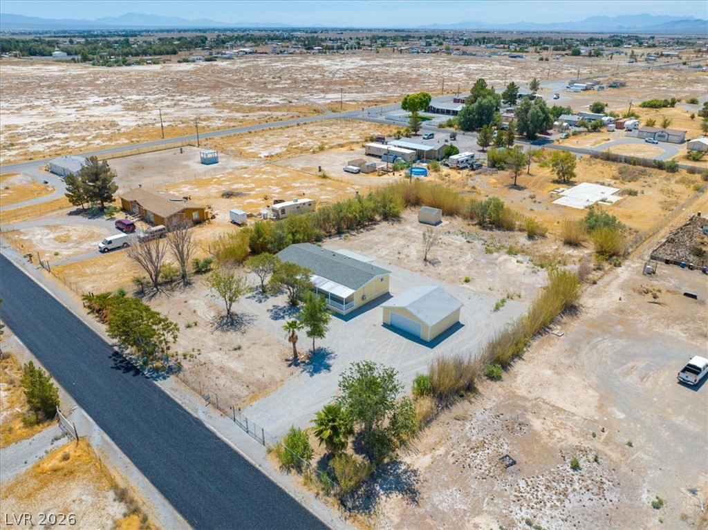 4081 Retread Road Pahrump, NV 89048 - Photo 90 of 98 An aerial perspective reveals a secluded residence amidst a vast, open landscape with distant mountains.