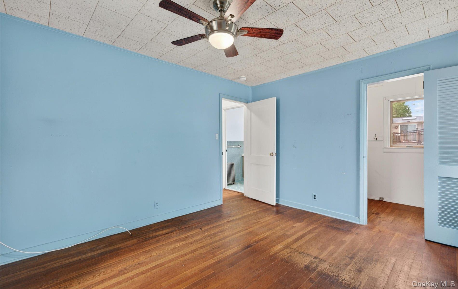 24 Purdue Road Glen Cove, NY 11542 - Photo 30 of 41 an empty room with wooden floor a ceiling fan and closet