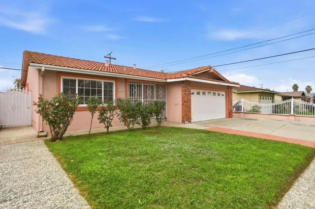 a front view of a house with a garden and plants