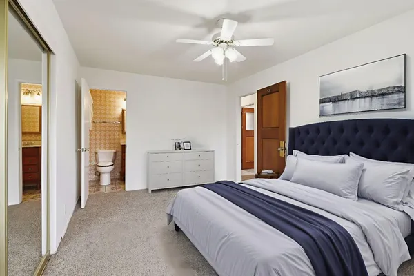 a bedroom with a large bed and a chandelier