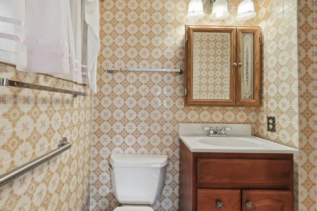 a bathroom with a toilet a sink and a window